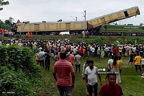 People look on at the site of a collision between an express passenger train and a goods train in Nirmaljote, near Rangapani station in India’s West Bangal state. At least seven people were killed when the trains collided in India’s West Bengal state, derailing three passenger carriages.
