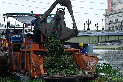 PERSONNEL from the Metropolitan Manila Development Authority (MMDA) Flood Control Division clean up the Pasig River in Manila in preparation for the rainy season.