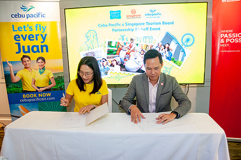 Candice Iyog, CEB chief marketing and customer experience officer (left) and Terrence Voon, STB executive director for Southeast Asia, sign the partnership renewal between CEB and STB.