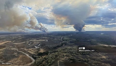 This handout image released by Alberta Wildfire shows smoke columns going in multiple directions due to shifting winds in Fort McMurray Forest Area, Alberta, on May 13, 2024. Evacuations have been ordered in oil-producing Fort McMurray, Alberta on May 14. Authorities have been bracing for another possibly devastating wildfire season, after Canada's worst ever last year that saw flames burning from coast to coast and charring more than 15 million hectares (37 million acres) of land.
