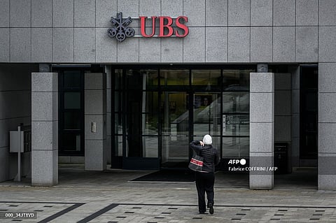 (FILES) A woman arrives at a Swiss UBS bank in Renens, western Switzerland on 19 February 2024.