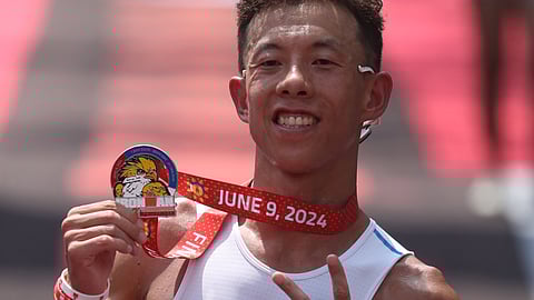 PENG Cheng Li celebrates after crossing the finish line in four hours and 20:05 minutes during the IRONMAN 70.3 Subic Bay on Sunday at the Subic Boardwalk.