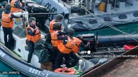 This frame grab from handout video taken on 17 June 2024 and released by the Armed Forces of the Philippines Public Affairs Office on June 19 shows a China coast guard member (C) appearing to try to puncture a Philippine inflatable boat with a weapon during an incident off Second Thomas Shoal in the South China Sea. The Philippine military said on June 19 the Chinese coast guard rammed and boarded Filipino navy boats in a violent confrontation in the South China Sea this week in which a Filipino sailor lost a thumb. China defended its actions, with its foreign ministry saying on Wednesday that "no direct measures" were taken against Filipino personnel.