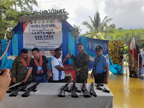 LANTAWAN, Basilan Mayor Nasser Abubakar (center) hands over a cal 50 Barret sniper rifle to 101st Infantry ‘Three Red Arrows’ Brigade Commander Brig. Gen. Alvin V. Luzon, while Basilan Gov. Hadjiman S. Hataman-Salliman (2nd from left) looks at the surrendered firearms.