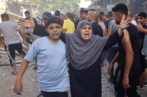 A woman reacts as people search for survivors after Israeli bombardment at Bureij refugee camp, central Gaza