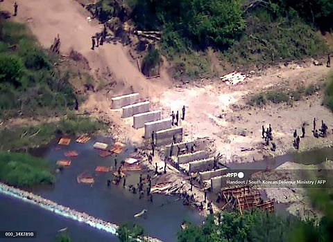NORTH Korean soldiers working at an undisclosed location near the heavily fortified border, as seen from a South Korean guard area.