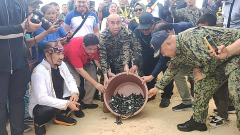 Undersecretary Mark Roa Gimenes (2nd from left) of the Presidential Management Staff released to the sea about 400 hatchlings or baby green sea turtles at Taganak Island and was assisted by Mayor Mohammad Faizal Jamalul (left), Naval Forces Western Mindanao Commander Commodore Francisco G. Tagamolia Jr. (3rd from left), Tawi-Tawi Gov. Ysmael ‘Mang’ Sali and other stakeholders.