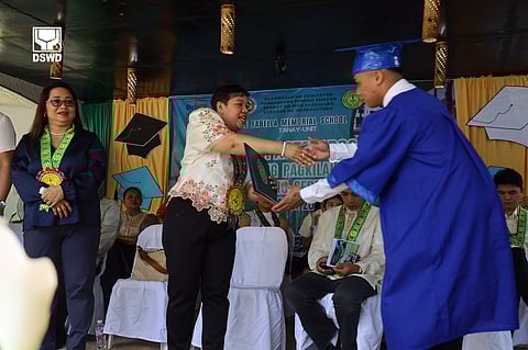 OFFICIAL of Jose Fabella Memorial School hands over a diploma to a graduating CICL.