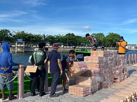 Police check on the smuggled cigarettes seized by authorities at the Naval Station Romulo Espaldon in Zamboanga City.