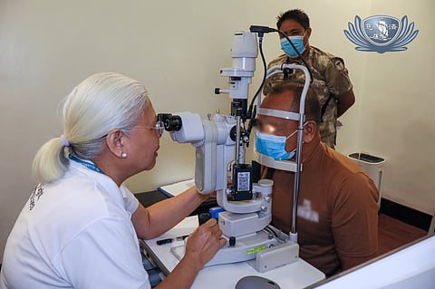 TCEC medical director Dr. Bernardita Navarro checks the eye of Mr. Ino.