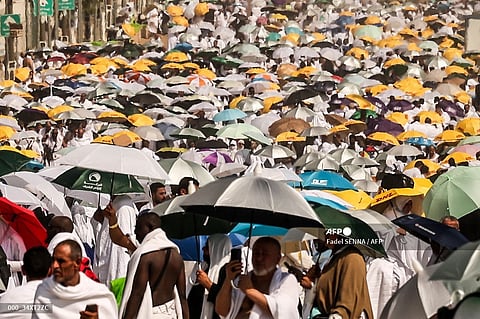Muslim pilgrims use umbrellas to shade themselves from the sun as they arrive at the base of Mount Arafat, also known as Jabal al-Rahma or Mount of Mercy, during the annual hajj pilgrimage on June 15, 2024.