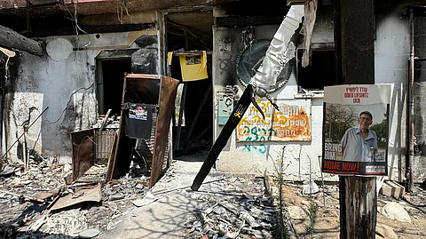 Hellish sight The house of freedom fighter Oded Lifshitz has been reduced into a huge pile of ashes following the deadly attack of the Hamas militant group in the kibbutz community in Nir Oz on 7 October. At left, photos of Israelis still held hostage by Hamas are displayed in leaflets and posters.