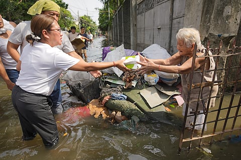 MALABON Representative Josephine Veronique R. Lacson-Noel hands hot meals donated by Ayala Foundation to a resident affected by flood.