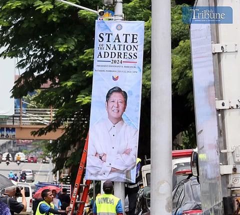MMDA staff put up banners announcing President Marcos' third SONA
