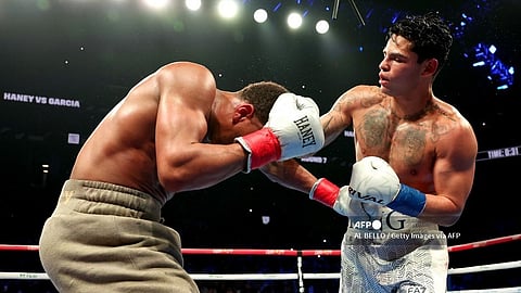 (FILES) Ryan Garcia (white trunks) punches Devin Haney (gray trunks) during their WBC Super Lightweight title bout at Barclays Center on 20 April 2024 in New York City.