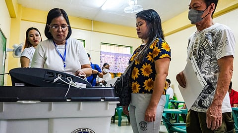 (FILE PHOTO) Voters are instructed to feed their ballots to the vote counting machine at the Pasong Tamo Elementary School, one of the few automated polling centers during the BSKE 2023 on Monday, 30 October 2023.