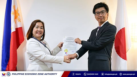 PEZA Deputy Director General Vivian Santos (left) and Kaneko Medical Philippine Inc. authorized representative Masaya Fukazawa show the certificate of registration at the PEZA office in Pasay City last 26 June.