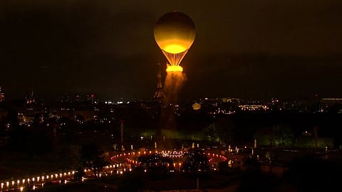 The olympic flame rises into the Paris night.