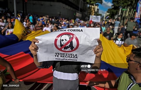 A supporter of Venezuelan President Nicolas Maduro holds a placard that reads "Maria Corina (Machado), Venezuela rejects you" during a rally in Caracas on July 31, 2024. Venezuelan President Nicolas Maduro said Wednesday he was willing to share evidence of his election win, with international pressure mounting for him to back up a disputed victory that has sparked deadly protests.