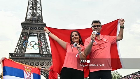 Silver medallists Turkey's Sevval Ilayda Tarhan (L) and Yusuf Dikec from the shooting 10m air pistol mixed team event pose before the Eiffel Tower at the Champions Park at Trocadero during the Paris 2024 Olympic Games in Paris on July 31, 2024.