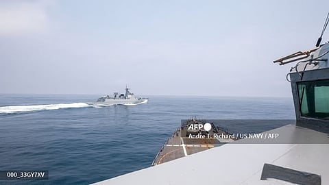 (FILES) This handout photo taken on 3 June 2023 by the US Navy shows the Arleigh Burke-class guided-missile destroyer USS Chung-Hoon observing the Chinese PLA Navy vessel Luyang III (top) while on a transit through the Taiwan Strait with the Royal Canadian Navy's HMCS Montreal.