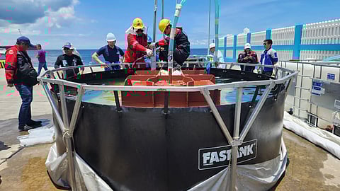 Personnel of Harbor Star Shipping Services, Inc. transfer oil to a tank during the siphoning simulation at Lamao Port, Limay, Bataan on Wednesday.