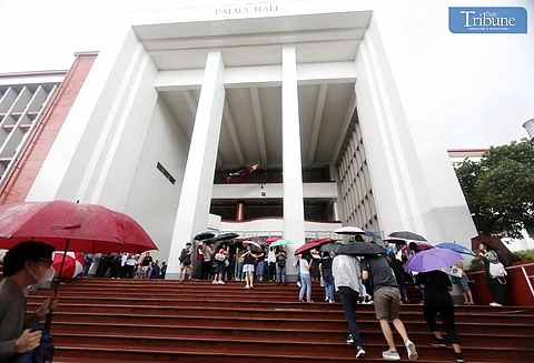 THE second batch of UPCAT examinees and their parents used umbrellas to cope with a sudden downpour of heavy rain at Palma Hall and University Avenue on Saturday, 10 August 2024. UP Diliman expects more than 30,000 examinees per day during the two-day admission test and advises motorists to find alternate routes.