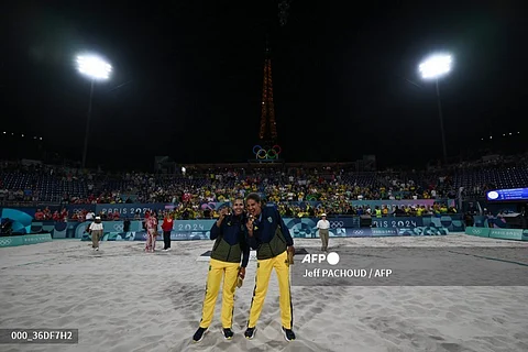 Gold medallists Eduarda Santos Lisboa (L) and Brazil's Ana Patricia Silva Ramos pose with their medals after the victory ceremony of the women's beach volleyball event during the Paris 2024 Olympic Games at the Eiffel Tower Stadium in Paris on August 9, 2024.