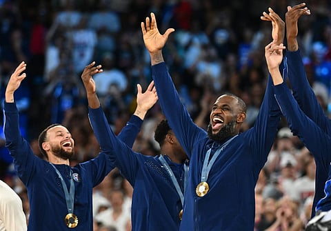 Steph Curry (left) and LeBron James celebrate the United States’ 98-87 victory over France in the Paris Olympics men’s basketball final on Saturday.