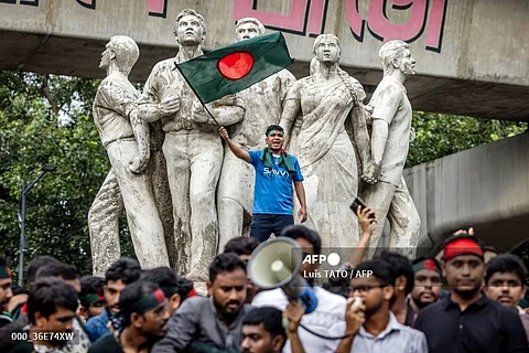 (FILE PHOTO) A student (C) waving Bangladesh's national flag, chants slogans during a protest to demand accountability and trial against the country's ousted Prime Minister Sheikh Hasina, near Dhaka University in the capital on August 12, 2024. Bangladesh was experiencing a "student-led revolution" after the ouster of premier Sheikh Hasina, the South Asian country's new interim leader Muhammad Yunus said.