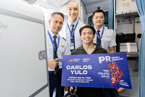 CARLOS Yulo celebrates his Olympic success with the crew of PR 8888 that landed in Manila on Tuesday night.