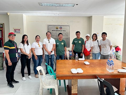 Starlite Holdings Corp. AVP Jason Cajustin (fourth from left) and employee volunteers, Brgy. Batis Chairperson Dino Geneson (fifth from left), and local officials attend the relief operation at Barangay Batis Hall in San Juan.