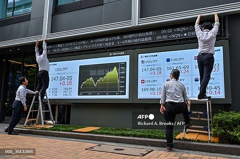 LOOK: Employees work on the exterior of a brokerage display showing the numbers of the Japanese yen versus US dollar (L) and against other currencies (R), along a street in Tokyo on August 14, 2024. | 📷 Richard A. Brooks / AFP