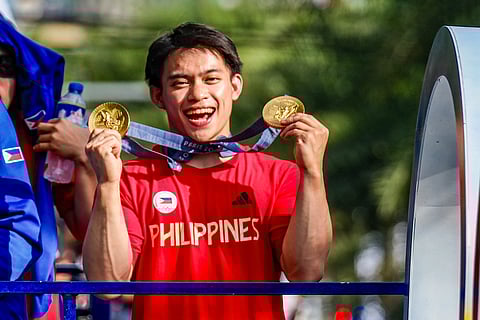 LOOK: Two-time gold medalist Carlos Yulo, are all smiles as he greet the supporters during the heroes' welcome parade along the streets of Manila and Pasay City on Wednesday, 14 August 2024.| Photo by Yummie Dingding/ PPA POOL