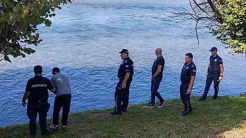 Serbian Police officers search a bank of the Drina River near the town of Ljubovija, Serbia.