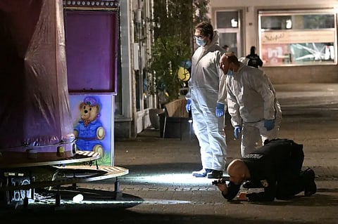 Forensic police inspect the area where at least three people were killed and several injured when a man attacked them with a knife in Solingen, western Germany