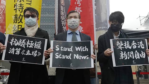 3 men holding pro-Stand News signs