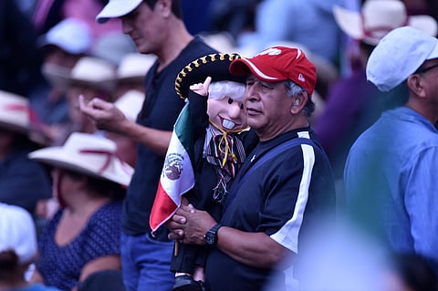 A supporter of Mexico’s President Andres Manuel Lopez Obrador holds a doll depicting the Mexican president dressed as a mariachi during the presentation of his last government report at the El Zocalo Square in Mexico City on 1 September 2024.