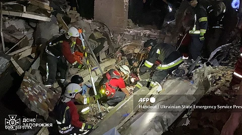 This handout photograph released on 3 September 2024 by Ukrainian State Emergency Service and taken on 2 September 2024 shows rescuers inspecting the rubble of a destroyed hotel after a Russian night strike in Zaporizhzhia, amid the Russian invasion of Ukraine. As a result of the attack 38 year-old woman and her 8 year-old son were killed, and her 12 year-old daughter was wounded and hospitalized, the Emergency service reported.