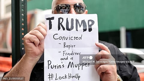 A protestor holds a sign after a Republican presidential nominee, former U.S. President Donald Trump press conference at Trump Tower on 6 September 2024 in New York City. Trump held a press conference hours after attending a federal appeals court attempting to get a new trial after a jury found he sexually abused and defamed E. Jean Carroll. A nine-member jury awarded Carroll $5 million in damages following a two-week trial last year and another jury awarded her $83.3 million in damages after finding Trump defamed her again in 2022.
