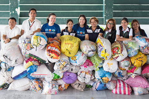 NESTLE Philippines volunteers with tons of plastic waste they collected for recycling.