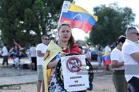 A supporter holds a sign reading '(current Venezuela's President Nicolas Maduro) murderer of Venezuela', upon the arrival of Venezuelan opposition presidential candidate for the Plataforma Unitaria Democratica party, Edmundo Gonzalez Urrutia at Madrid's Torrejon de Ardoz military airport on 8 September, 2024. Spain will "obviously" grant political asylum to Venezuelan opposition leader Edmundo Gonzalez Urrutia, Foreign Minister said on 8 September, 2024. Gonzalez Urrutia left Venezuela on 7 September aboard a Spanish military aircraft after spending several days seeking refuge in the Spanish embassy in Caracas, where he fled after authorities issued an arrest warrant for him after he disputed the re-election of President Nicolas Maduro in July's election.