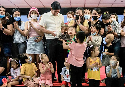 Marcos stands with young cancer patients