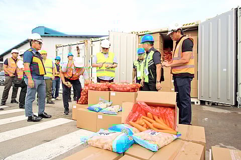 Agriculture Secretary Francisco Tiu Laurel ( center) and BoC Port of Subic Atty. Ricardo Uy Morales II (second to the right) inspect the smuggled contrabands presented to the media on Wednesday at the New Container Terminal. The P136 million worth of smuggled items that were found inside seven container vans include fake cigarettes and vegetables that came from Taiwan and China, respectively.