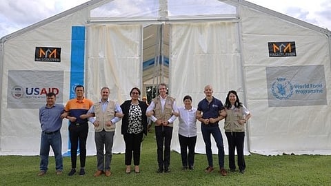 USAID Mission Director Ryan Washburn (5th from left) and Cagayan Provincial Administrator Atty. Maria Rosario Mamba-Villaflor (4th from left) with provincial government staff stand in front of a mobile storage unit handed over by USAID and the World Food Programme.