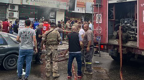People and first responders gather at the scene of a reported device explosion in Saida in southern Lebanon on 18 September 2024. A second wave of device explosions killed three people in Hezbollah strongholds of Lebanon on 18 September, raising fears of an all-out war between Israel and the Iran-backed militants.