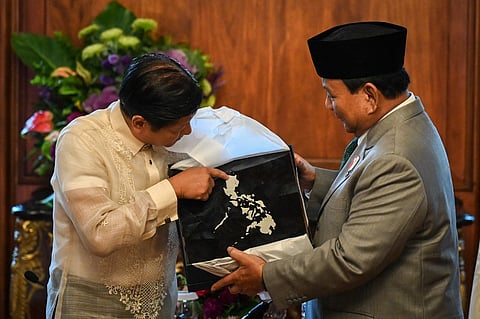Philippines President Ferdinand Marcos Jr (L) gives a token to Indonesia’s President-elect Prabowo Subianto during a courtesy call at Malacañan Palace in Manila on 20 September, 2024.
