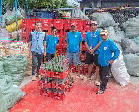 REPRESENTATIVES of Barangay Tejeros in Makati City pose with their collected empty glass bottles.