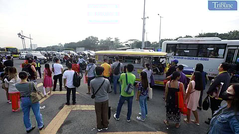 Commuters wait for public transport at Philcoa in Quezon City as transport groups Manibela and Piston hold a two-day strike in protest of the government's PUV modernization program consolidation.