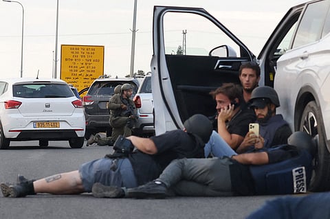 Under fire Journalists take cover behind cars as Israeli soldiers take positions during clashes with Hamas fighters near kibbutz Gevim, close to the border with Gaza on 7 October 2023. The day would be considered by Israel as its worst since the Holocaust.